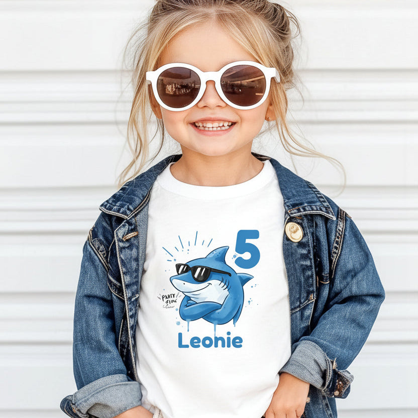 Cooles Geburtstagsshirt Hai für Kinder mit Name und Zahl personalisiert. Lustiges Geburtstags-T-Shirt für Jungen und Mädchen mit Hai Motiv, perfekt als Geburtstagsoutfit zum 3., 4., 5., 6. oder 7. Geburtstag. Ideal für Kindergeburtstag, Mottoparty oder als Kindergeburtstagsgeschenk. Personalisiertes T-Shirt Kinder mit Tiermotiv, Hai Design, für Jungen und Mädchen. Kinder T-Shirt Hai, Geburtstags-T-Shirt mit Zahl, Geburtstagsshirt Junge, Geburtstagsshirt Mädchen. personalisiertes T-Shirt Kinder