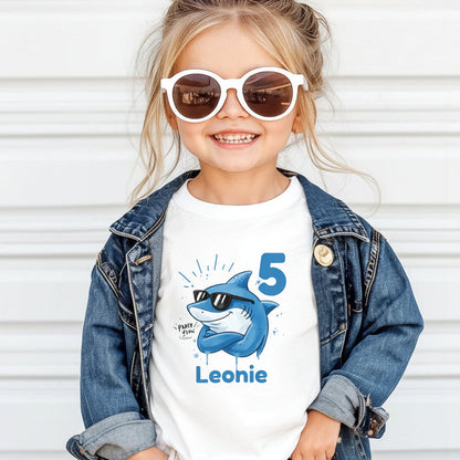 Cooles Geburtstagsshirt Hai für Kinder mit Name und Zahl personalisiert. Lustiges Geburtstags-T-Shirt für Jungen und Mädchen mit Hai Motiv, perfekt als Geburtstagsoutfit zum 3., 4., 5., 6. oder 7. Geburtstag. Ideal für Kindergeburtstag, Mottoparty oder als Kindergeburtstagsgeschenk. Personalisiertes T-Shirt Kinder mit Tiermotiv, Hai Design, für Jungen und Mädchen. Kinder T-Shirt Hai, Geburtstags-T-Shirt mit Zahl, Geburtstagsshirt Junge, Geburtstagsshirt Mädchen. personalisiertes T-Shirt Kinder