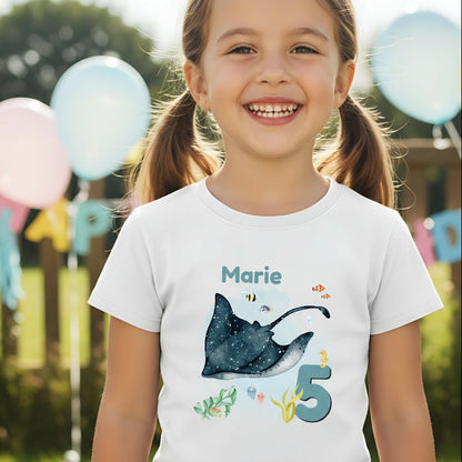 Personalisiertes Geburtstagsshirt für Kinder mit großem Rochen, tropischen Fischen, Algen, Name und Geburtstagszahl. Individuelles Kindergeburtstags-Outfit für Mädchen und Jungen mit Unterwasser-Motiv und Meerestiere-Design. Perfekt als Geburtstags-T-Shirt mit Namen, persönliches Geburtstagsgeschenk für Kinder oder Outfit für Meerjungfrauen-Party, Unterwasserparty oder Ozean-Geburtstag. Personalisierbares Kinder-Shirt mit Rochen, Zahl und Namen. T-Shirt zum Geburtstag für kleine Meeresfans und Ozean-Liebhab