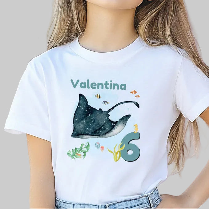Personalisiertes Geburtstagsshirt für Kinder mit großem Rochen, tropischen Fischen, Algen, Name und Geburtstagszahl. Individuelles Kindergeburtstags-Outfit für Mädchen und Jungen mit Unterwasser-Motiv und Meerestiere-Design. Perfekt als Geburtstags-T-Shirt mit Namen, persönliches Geburtstagsgeschenk für Kinder oder Outfit für Meerjungfrauen-Party, Unterwasserparty oder Ozean-Geburtstag. Personalisierbares Kinder-Shirt mit Rochen, Zahl und Namen. T-Shirt zum Geburtstag für kleine Meeresfans und Ozean-Liebhab