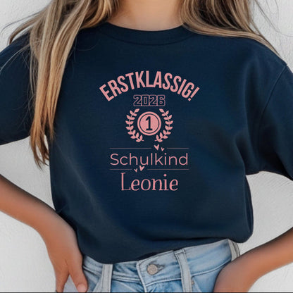 Personalisiertes Schulkind T-Shirt 2026 für Mädchen mit rosa Motiv „Erstklassig“, Einschulungsshirt mit Name, Bio-Baumwolle, perfekt als Geschenk zum Schulanfang 2026. Schulkind Shirt 1. Klasse, T-Shirt zur Einschulung, Zuckertüte Geschenk Mädchen, Erstklässler T-Shirt mit Jahreszahl, Lorbeerkranz und Zahl 1. Ideal als Einschulungsgeschenk, Abschied Kindergarten, Schulkind Outfit 2026 für Mädchen, T-Shirt Einschulungsfeier, Schulstart Kleidung mit Namen Erstklassig Schulkind T-Shirt 2026 Mädchen