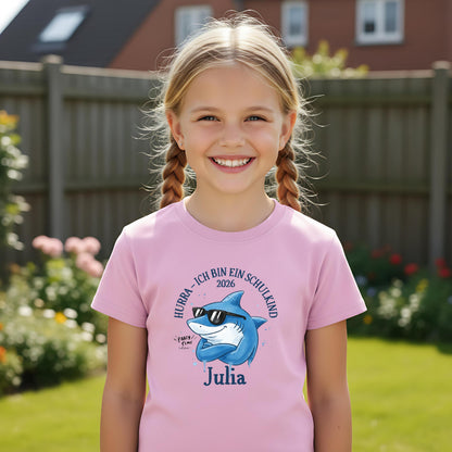 Cooles Schulkind T-Shirt 2026 mit Hai-Motiv, perfekt für Jungen zur Einschulung. Ideal als Geschenk zum Schulanfang für mutige Kinder, die mit Stil in die 1. Klasse starten. Das T-Shirt zur Einschulung besteht aus 100 % Bio-Baumwolle und kann mit Namen personalisiert werden. Perfekt als Einschulung Shirt Junge, T-Shirt endlich Schulkind, Geschenk Einschulung Kind, T-Shirt für Erstklässler oder Bye Bye Kindergarten Geschenk. Dieses Einschulungsshirt bringt und Vorfreude auf den Schulstart