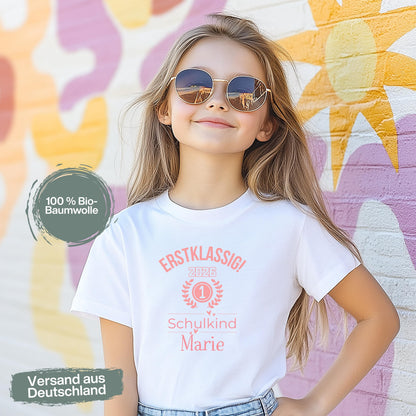 Personalisiertes Schulkind T-Shirt 2026 für Mädchen mit rosa Motiv „Erstklassig“, Einschulungsshirt mit Name, Bio-Baumwolle, perfekt als Geschenk zum Schulanfang 2026. Schulkind Shirt 1. Klasse, T-Shirt zur Einschulung, Zuckertüte Geschenk Mädchen, Erstklässler T-Shirt mit Jahreszahl, Lorbeerkranz und Zahl 1. Ideal als Einschulungsgeschenk, Abschied Kindergarten, Schulkind Outfit 2026 für Mädchen, T-Shirt Einschulungsfeier, Schulstart Kleidung mit Namen Erstklassig Schulkind T-Shirt 2026 Mädchen