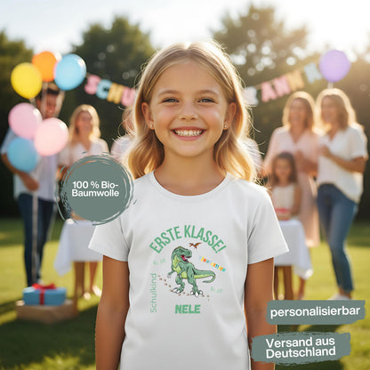 Personalisiertes Schulkind T-Shirt 2026 mit grünem Dinosaurier-Motiv und Spruch „Erste Klasse – Dinotastisch!“. Einschulungsshirt mit Name oder ohne, ideal als Geschenk zur Einschulung, für Kita Abschied, Einschulungsfeier oder ersten Schultag. T-Shirt Schulkind für Jungen und Mädchen, geeignet als Erstklässler T-Shirt, Tschüss Kindergarten Shirt, Schulkind Outfit oder Schulanfang Geschenk. Einschulung T-Shirt für Dinofans – stark, liebevoll, hochwertig und perfekt für den Schulstart 2026.