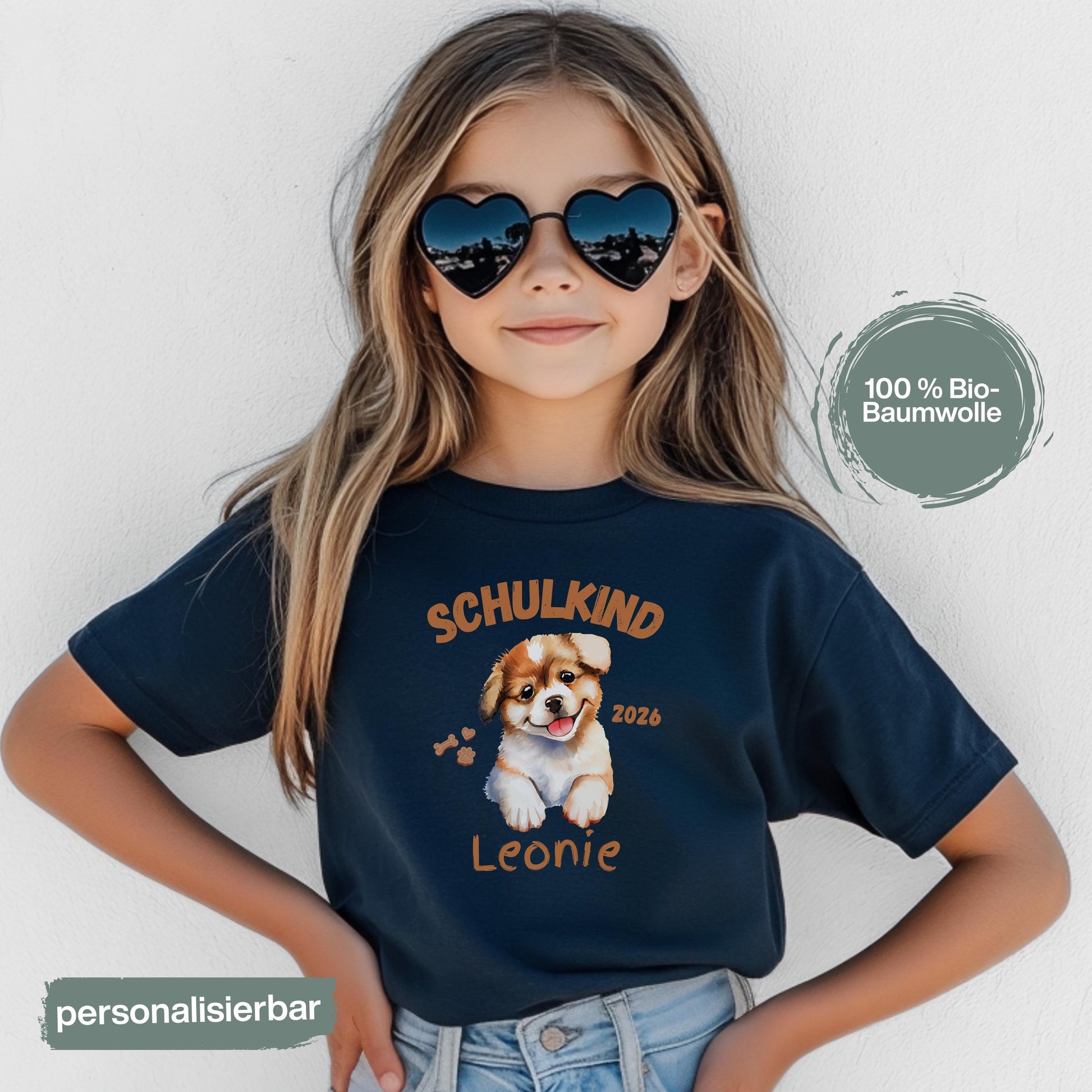 Personalisiertes Schulkind T-Shirt 2026 mit süßem Hundemotiv, ideal als Geschenk zur Einschulung für Mädchen und Jungen. Einschulungsshirt mit Name, Hund und „Schulkind 2026“ Schriftzug. Perfekt für den ersten Schultag, Abschied vom Kindergarten, Einschulungsfeier oder als Teil der Schultüte. T-Shirt zur Einschulung für Hundefans und Tierfreunde. Bio-Baumwoll Shirt für Erstklässler als Einschulungsgeschenk, Schulstart Outfit oder Erinnerung an den Schulanfang 2026. T-Shirt Schulkind Hund