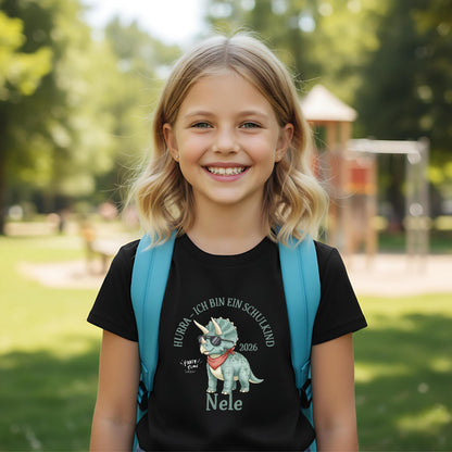 T-Shirt zur Einschulung 2026 mit Dino-Motiv – perfekt für Jungen, die stolz Schulkind werden. Personalisiertes Schulkind T-Shirt mit Name, ideal als Geschenk zur Einschulung oder für die Schultüte. Triceratops mit Sonnenbrille und Halstuch sorgt für Spaß und Selbstbewusstsein beim Schulstart. Hochwertiges Einschulung Shirt Junge aus 100 % Bio-Baumwolle, bequem und robust. Ein liebevolles, witziges T-Shirt für Erstklässler und ein ideales Bye Bye Kindergarten Abschiedsgeschenk.