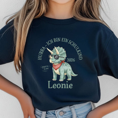 T-Shirt zur Einschulung 2026 mit Dino-Motiv – perfekt für Jungen, die stolz Schulkind werden. Personalisiertes Schulkind T-Shirt mit Name, ideal als Geschenk zur Einschulung oder für die Schultüte. Triceratops mit Sonnenbrille und Halstuch sorgt für Spaß und Selbstbewusstsein beim Schulstart. Hochwertiges Einschulung Shirt Junge aus 100 % Bio-Baumwolle, bequem und robust. Ein liebevolles, witziges T-Shirt für Erstklässler und ein ideales Bye Bye Kindergarten Abschiedsgeschenk.