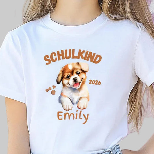 Personalisiertes Schulkind T-Shirt 2026 mit süßem Hundemotiv, ideal als Geschenk zur Einschulung für Mädchen und Jungen. Einschulungsshirt mit Name, Hund und „Schulkind 2026“ Schriftzug. Perfekt für den ersten Schultag, Abschied vom Kindergarten, Einschulungsfeier oder als Teil der Schultüte. T-Shirt zur Einschulung für Hundefans und Tierfreunde. Bio-Baumwoll Shirt für Erstklässler als Einschulungsgeschenk, Schulstart Outfit oder Erinnerung an den Schulanfang 2026. T-Shirt Schulkind Hund