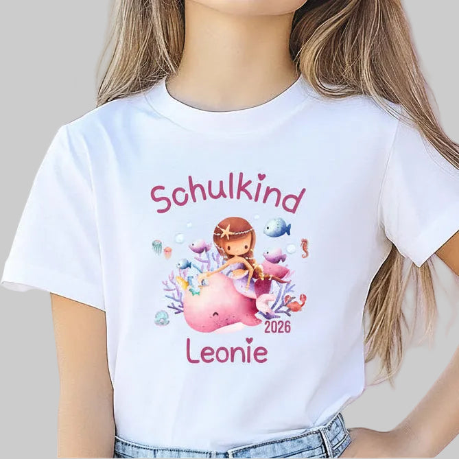 Personalisiertes Schulkind T-Shirt 2026 mit Meerjungfrau für Mädchen zur Einschulung. Einschulungsshirt mit Wal und Korallen, ideal als Geschenk zur Einschulung für Mädchen, Meerfans und kleine Träumerinnen. Erstklässler T-Shirt personalisiert mit Name und Jahr, geeignet für Einschulungsfeier, Kita-Abschied oder ersten Schultag. Hochwertiges Bio-Baumwolle T-Shirt als Schulanfang Geschenk oder Schultüten-Inhalt. Schulkind Outfit 2026, T-Shirt Schulkind Meerjungfrau 2026, Einschulungsshirt Mädchen