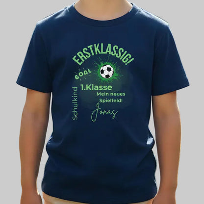 Personalisiertes Schulkind T-Shirt 2026 mit Fußball Motiv, ideal als Geschenk zur Einschulung. Einschulungsshirt für Jungen mit Ball-Design und dem Spruch „1. Klasse – Mein neues Spielfeld“. Perfekt als Erstklässler T-Shirt, Fußball T-Shirt zur Einschulung oder Schulstart Shirt für kleine Kicker. Personalisiert mit Name und Jahreszahl 2026. Ideal für Einschulung 2026, Kita Abschied, Schulanfang, Einschulungsfeier oder als sportliches Outfit für den ersten Schultag.