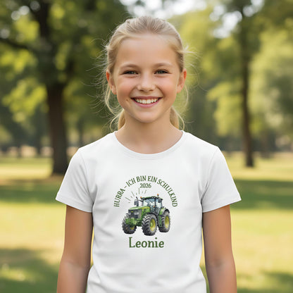 T-Shirt zur Einschulung 2026 mit grünem Traktor für Jungen, perfekt als Geschenk zum Schulanfang. Das Schulkind T-Shirt besteht aus 100 % Bio-Baumwolle, ist personalisierbar mit Namen und begeistert kleine Traktor-Fans am ersten Schultag. Ideal als Einschulung Shirt Junge, T-Shirt endlich Schulkind, Geschenk Einschulung Kind oder Abschiedsgeschenk vom Kindergarten. Dieses T-Shirt für Erstklässler verbindet Stil und Bedeutung, ein starkes Bye Bye Kindergarten Motiv für kleine Schulanfänger