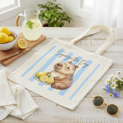 Capybara Stofftasche aus hochwertiger Baumwolle mit niedlichem Capybara und frischen Zitronen im sommerlichen Streifen-Design. Der Stoffbeutel zeigt den Spruch „Squeeze the Day“ und eignet sich als Einkaufstasche, Tragetasche oder Baumwolltasche für Alltag, Shopping, Urlaub und Freizeit. Perfekt als Capybara Tasche, Capybara Geschenk oder Geschenk für Capybara Fans und Tierliebhaber. Robuster Stoffbeutel mit hochwertigem Druck, langen Henkeln und Sommermotiv, ideal als nachhaltige Einkaufstasche
