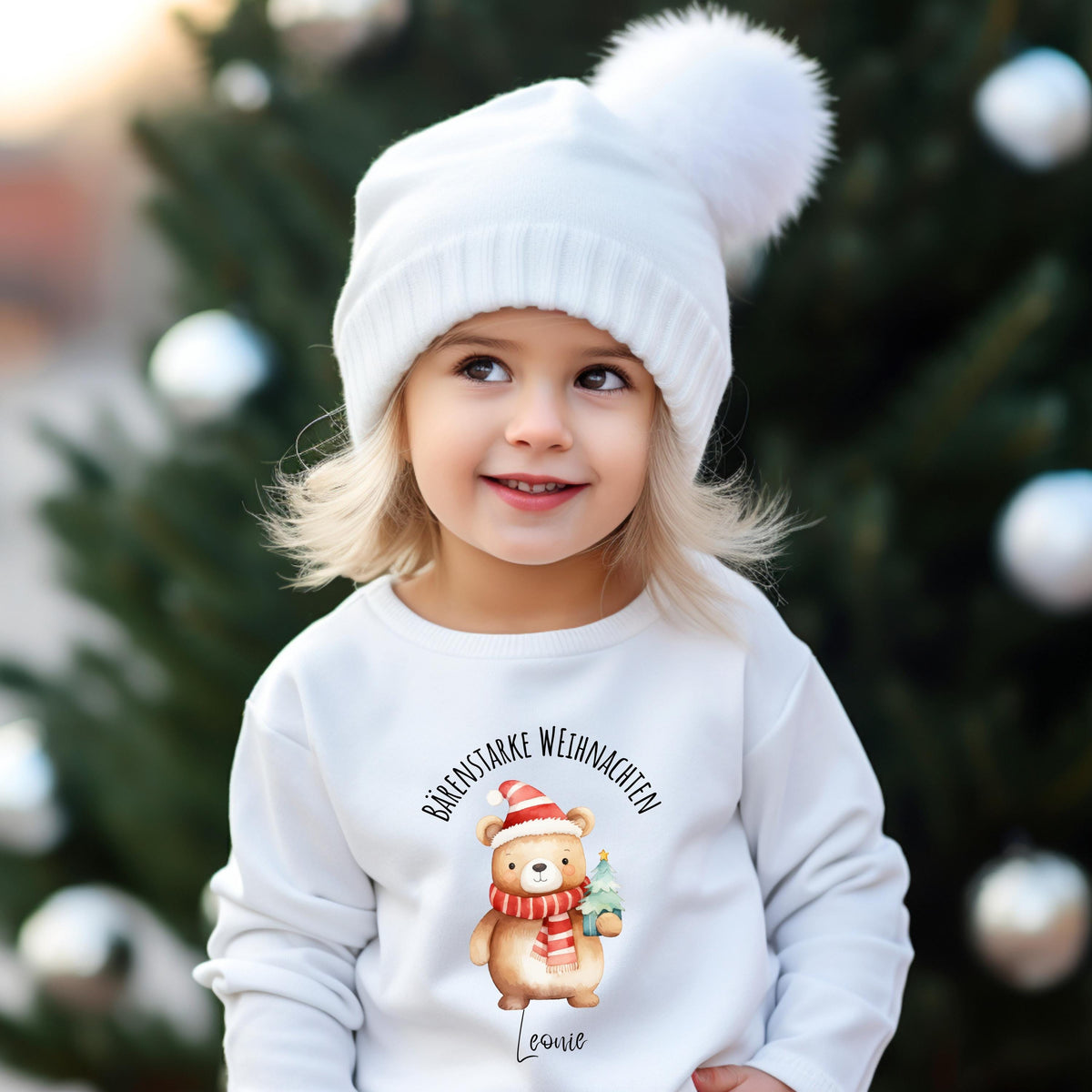 Zwei Kinder tragen ein personalisiertes Weihnachtsoutfit mit süßem Bärenmotiv – als Weihnachtspullover, Weihnachts-T-Shirt oder Baby Weihnachtsbody. Der niedliche Weihnachtsbär mit roter Mütze, Geschenk und individuellem Namen ist ideal als Geschenk für Jungen und Mädchen, als Baby Weihnachten Outfit oder festlicher Geschwisterlook. Perfekt für Weihnachtsfotos, Kita-Feiern, Krippenfeste oder als Partnerlook für Geschwister. Hochwertig & personalisiert – ein bärenstarker Hingucker zu Weihnachten.