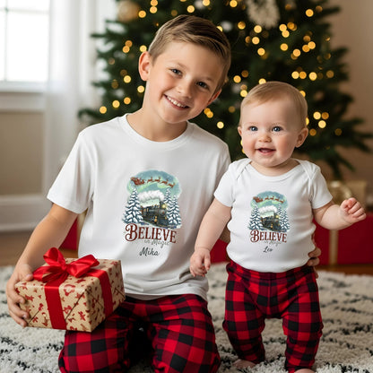 Weihnachtspullover Familie mit nostalgischem Weihnachtszug und Santa-Schlitten – liebevoll personalisiert mit Namen wie "Familie Müller". Das detailreiche Motiv zeigt eine dampfende Lokomotive im verschneiten Tannenwald, darüber zieht der Weihnachtsmann mit Rentieren durch den Polarhimmel. Ideal für Eltern, Kinder & Babys im festlichen Partnerlook. Perfekt als Familien-Weihnachtsoutfit, Geschenk oder Geschwistershirt für Weihnachten, Heiligabend und Familienfotos.Partnerlook Weihnachte
