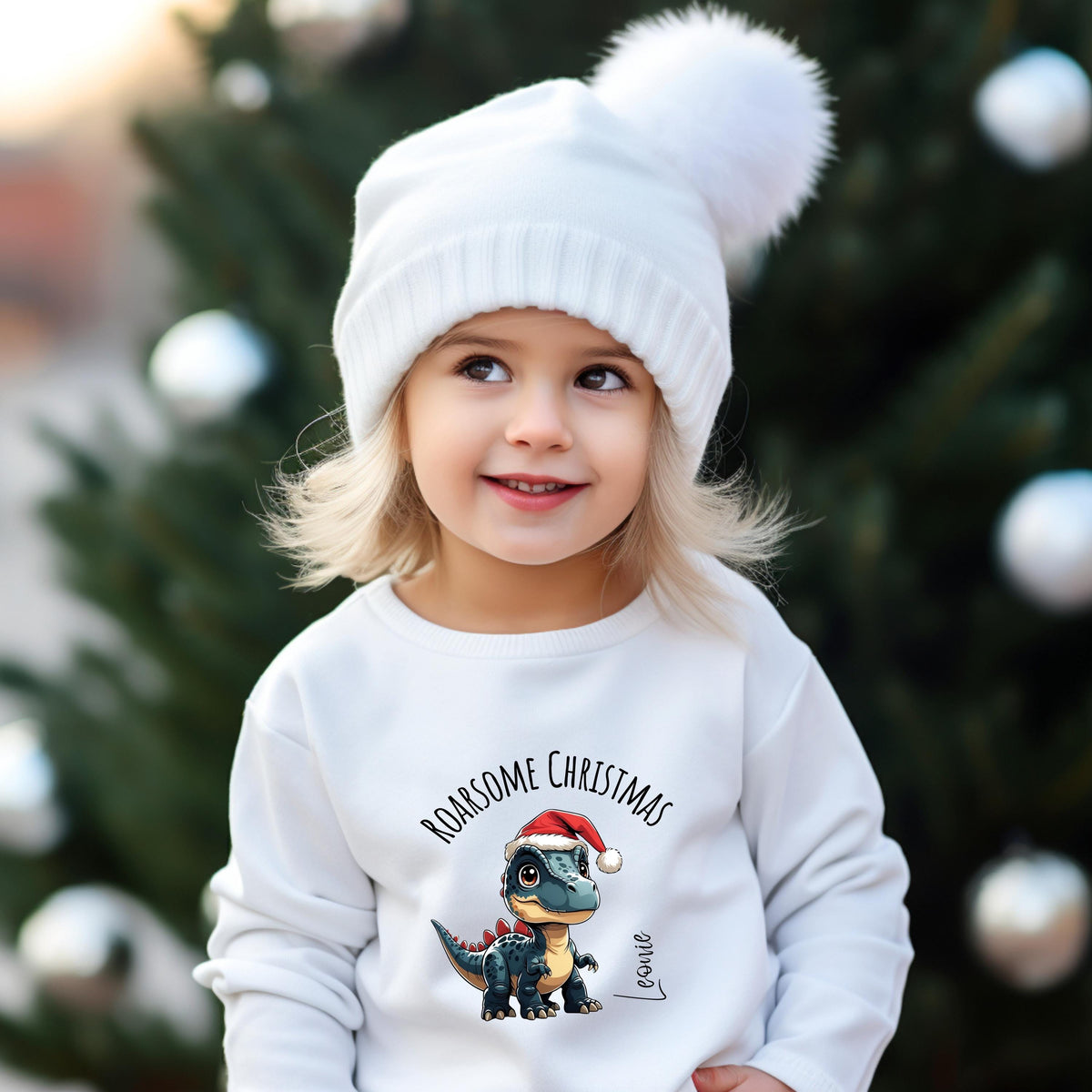Weihnachtspullover für Kinder mit süßem Dino-Motiv und Personalisierung mit Namen. Perfekt als individuelles Weihnachtsgeschenk für kleine Dino-Fans – egal ob als Sweatshirt, T-Shirt oder Body (kurzarm/langarm). Ideal für festliche Anlässe wie Weihnachtsfeiern, Fotos und als Geschwister-Outfit. Hochwertiger Druck, weiche Materialien, liebevoll gestaltet. Ein Weihnachtsoutfit, das für leuchtende Augen sorgt und Kindheitserinnerungen schafft. Jetzt personalisiert bestellen!