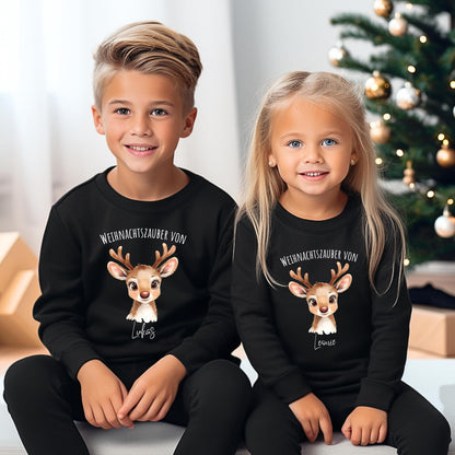 Weihnachtspullover mit niedlichem Rentier-Motiv und dem Text „Weihnachtszauber von [Name]“ – personalisierbar und ideal als Weihnachtsoutfit für Kinder. Perfekt für Jungen, Mädchen oder Babys als festlicher Pullover, Weihnachts-T-Shirt oder Babybody. Der süße Rentier-Print mit Geweih und großen Augen macht das Design zum Hingucker auf Weihnachtsfotos, bei der Bescherung oder im Partnerlook mit Geschwistern. Eine liebevolle Geschenkidee für die Feiertage mit persönlichem Namen.