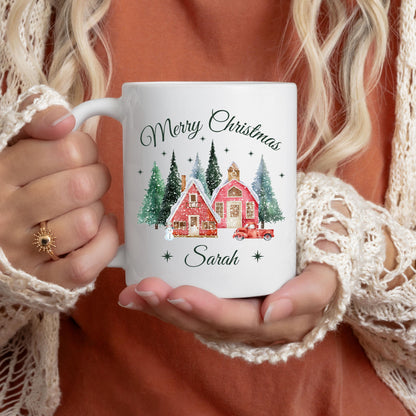 Personalisierte Weihnachtstasse mit Weihnachtsdorf-Motiv, dekoriert mit verschneiten Häusern, Tannenbäumen, rotem Auto und dem Schriftzug „Merry Christmas“. Unten lässt sich der Name individuell einfügen. Die festliche Keramiktasse ist ideal als Weihnachtsgeschenk für Familie, Freunde oder Kolleg:innen. Perfekt geeignet als Wichtelgeschenk, Geschenkidee für die Adventszeit oder als liebevoll gestalteter Winterbecher mit Namenspersonalisierung, für festliche Momente mit Herz und Stil.