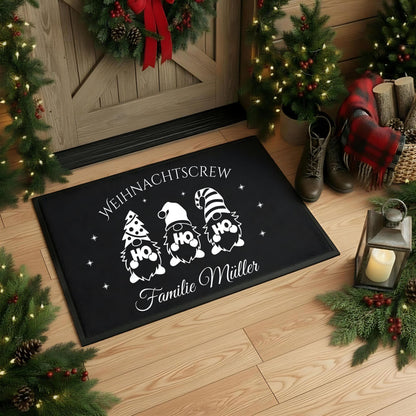 Personalisierte Fußmatte mit Weihnachtsdesign „Weihnachtscrew“ – drei Gnome mit HO HO HO-Motiven und Wunschname der Familie darunter. Diese schwarze Weihnachtsfußmatte ist rutschfest, wetterbeständig und ideal als individuelle Fußmatte für den Eingangsbereich zu Weihnachten. Perfekt als Geschenkidee für Familien, als Weihnachts-Willkommensmatte oder Türmatte mit Namen. Ein festlicher Blickfang für alle, die Weihnachten lieben und den Eingangsbereich dekorativ und persönlich gestalten wollen.