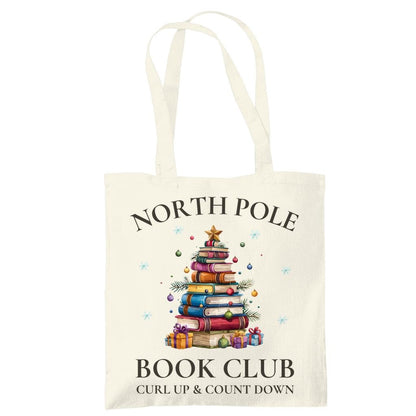 Baumwoll-Stofftasche mit weihnachtlichem Motiv: Ein Bücherbaum mit Stern und Geschenken symbolisiert den „North Pole Book Club“. Perfekt als Jutebeutel Weihnachten für Leseratten, Bücherfreunde, Bibliophile oder Buchclub-Mitglieder. Ideales Geschenk für Buchliebhaber und als nachhaltige Geschenkverpackung mit Buchthema zur Adventszeit. Baumwolltasche für Weihnachten & Buchfans. WeihnachtsStofftasche für Bücherfreunde! Der Jutebeutel ist das perfekte Geschenk für Buchliebhaber zur Adventszeit.