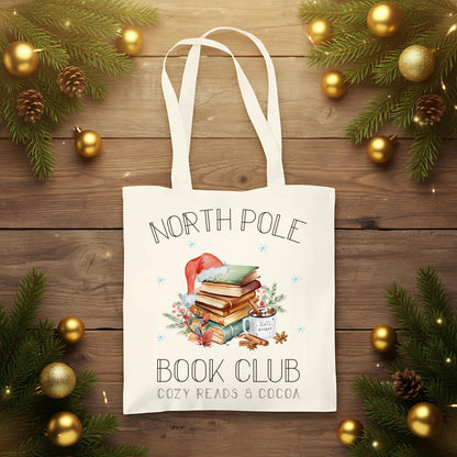 Baumwoll‑Jutebeutel mit weihnachtlichem Bücherbaum‑Motiv und Schriftzug „North Pole Book Club“. Ideal als Stofftasche Weihnachten für Leseratten, Buchliebhaber und Bibliophile – passend als Geschenk oder Einkaufstasche in der Advents‑ und Winterzeit. Hochwertige Baumwolltasche, langlebiger Druck, lange Henkel, umweltfreundlich und vielseitig nutzbar. Perfekt als Weihnachts‑Geschenktasche, Bücherbeutel oder nachhaltige Tasche mit Weihnachtsmotiv für Freunde, Familie oder für dich selbst.