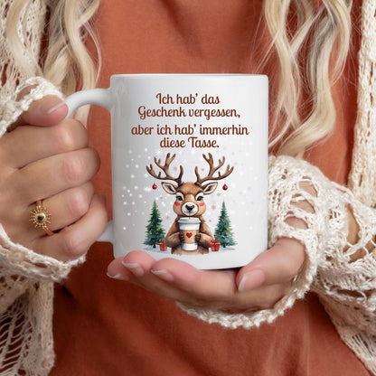 Lustige Weihnachtstasse mit Spruch „Ich hab das Geschenk vergessen, aber ich hab immerhin diese Tasse“, Rentier mit Kaffeebecher, Schnee und Tannen. Weihnachtsbecher aus Keramik, als Geschenk Weihnachten für Kollegin, Freund, Freundin oder Familie. Perfekt als Wichtelgeschenk, Nikolausgeschenk oder kleines Geschenk. Wintertasse mit Humor für Frauen, Männer und Paare. Geschenkidee Weihnachten, Kaffeetasse mit Spruch. Für Weihnachtsfeier oder Advent. Lustige Tasse Weihnachten mit Rentier-Motiv