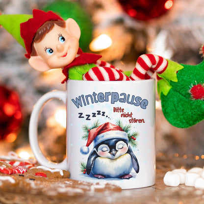 Lustige Weihnachtstasse mit Pinguinmotiv und Spruch „Winterpause – Bitte nicht stören“ – perfektes Geschenk für Kollegen, Freund, Freundin oder Familie zu Weihnachten. Der schläfrige Pinguin mit Weihnachtsmütze und heißem Getränk bringt Ruhe in jede Kaffeepause. Hochwertige Keramiktasse für festliche Jahreszeit. Ideal als Nikolausgeschenk, Wichtelgeschenk, kleines Weihnachtsgeschenk oder humorvolle Aufmerksamkeit für Homeoffice, Büro oder Sofa-Zeit. Perfekt für Kaffee, Tee oder heiße Schokolade.