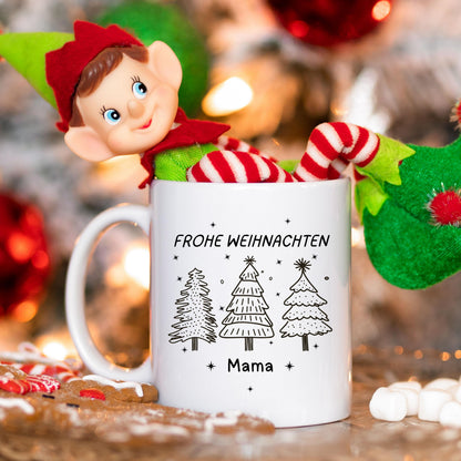 Weiße Keramiktasse mit festlichem Weihnachtsdesign, bestehend aus drei Tannenbäumen in Schwarz-Weiß. Darüber steht der Schriftzug „Frohe Weihnachten“ in Großbuchstaben, darunter ein personalisierter Name. Die minimalistische Gestaltung macht die Tasse zu einem tollen Begleiter durch die Adventszeit. Ideal als personalisierbares Weihnachtsgeschenk für Partner, Kinder, Freunde oder Familie. Perfekt als Nikolausgeschenk, für den Adventskalender oder als liebevolle Wichtelidee mit persönlicher Note.