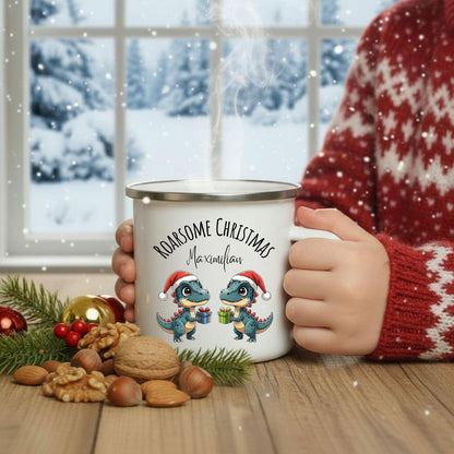 Emailletasse für Kinder mit Weihnachtsmotiv: Zwei süße Dinosaurier tragen Weihnachtsmützen und halten Geschenke. Darüber steht der Schriftzug „Roarsome Christmas“, darunter kann der Name personalisiert werden. Die festliche Kindertasse ist ideal als personalisierte Weihnachtsgeschenkidee für Jungen und Mädchen. Aus robuster Emaille gefertigt, perfekt für Kakao oder Tee. Ein tolles Weihnachtsgeschenk für Dino-Fans – kindgerecht, fröhlich und liebevoll gestaltet.
