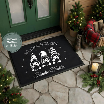 Personalisierte Fußmatte mit Weihnachtsdesign „Weihnachtscrew“ – drei Gnome mit HO HO HO-Motiven und Wunschname der Familie darunter. Diese schwarze Weihnachtsfußmatte ist rutschfest, wetterbeständig und ideal als individuelle Fußmatte für den Eingangsbereich zu Weihnachten. Perfekt als Geschenkidee für Familien, als Weihnachts-Willkommensmatte oder Türmatte mit Namen. Ein festlicher Blickfang für alle, die Weihnachten lieben und den Eingangsbereich dekorativ und persönlich gestalten wollen.