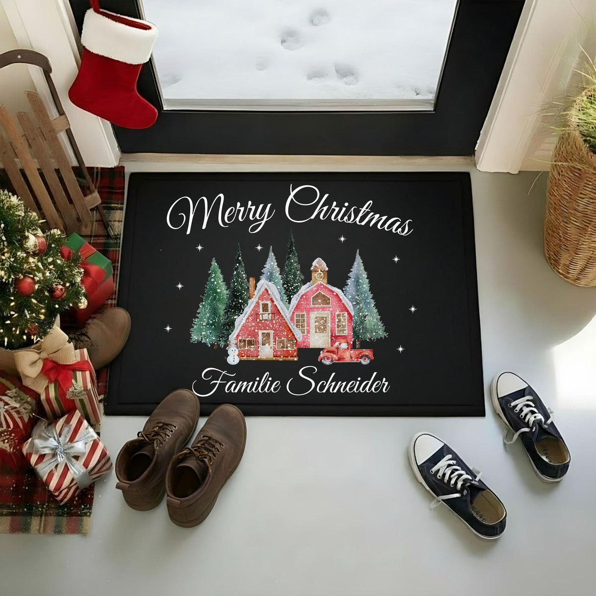 Personalisierte Weihnachtsfußmatte „Merry Christmas – Familie Schneider“ im Eingangsbereich vor einer Glastür mit Schnee dahinter. Zwei rote Winterhäuser, schneebedeckte Tannen, Sterne und ein rotes Auto schmücken die schwarze Matte. Schuhe, Weihnachtsgeschenke, kleiner Tannenbaum, Schlitten und roter Weihnachtsstrumpf ergänzen die Szene. Die rechteckige Türmatte mit Gummirand und Oberfläche aus 100 % Polypropylen gibt es in 40 × 60 oder 50 × 70 cm. Weihnachtsgeschenk mit Wunschname für Familie oder Paare.