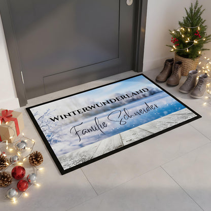 Personalisierte Weihnachtsfußmatte mit dem Schriftzug „Winterwunderland“ und Familiennamen, winterliches Design mit Frost und Schneelandschaft. Diese Türmatte Weihnachten eignet sich ideal als festliche Dekoration für den Eingangsbereich und als Geschenkidee zur Weihnachtszeit. Die rutschfeste, pflegeleichte Fußmatte ist perfekt für Innenräume oder überdachte Außenbereiche. Winterliche Türmatte mit Namen – personalisierbar, hochwertig, robust und ein weihnachtlicher Blickfang für Familien