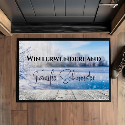 Personalisierte Weihnachtsfußmatte mit dem Schriftzug „Winterwunderland“ und Familiennamen, winterliches Design mit Frost und Schneelandschaft. Diese Türmatte Weihnachten eignet sich ideal als festliche Dekoration für den Eingangsbereich und als Geschenkidee zur Weihnachtszeit. Die rutschfeste, pflegeleichte Fußmatte ist perfekt für Innenräume oder überdachte Außenbereiche. Winterliche Türmatte mit Namen – personalisierbar, hochwertig, robust und ein weihnachtlicher Blickfang für Familien