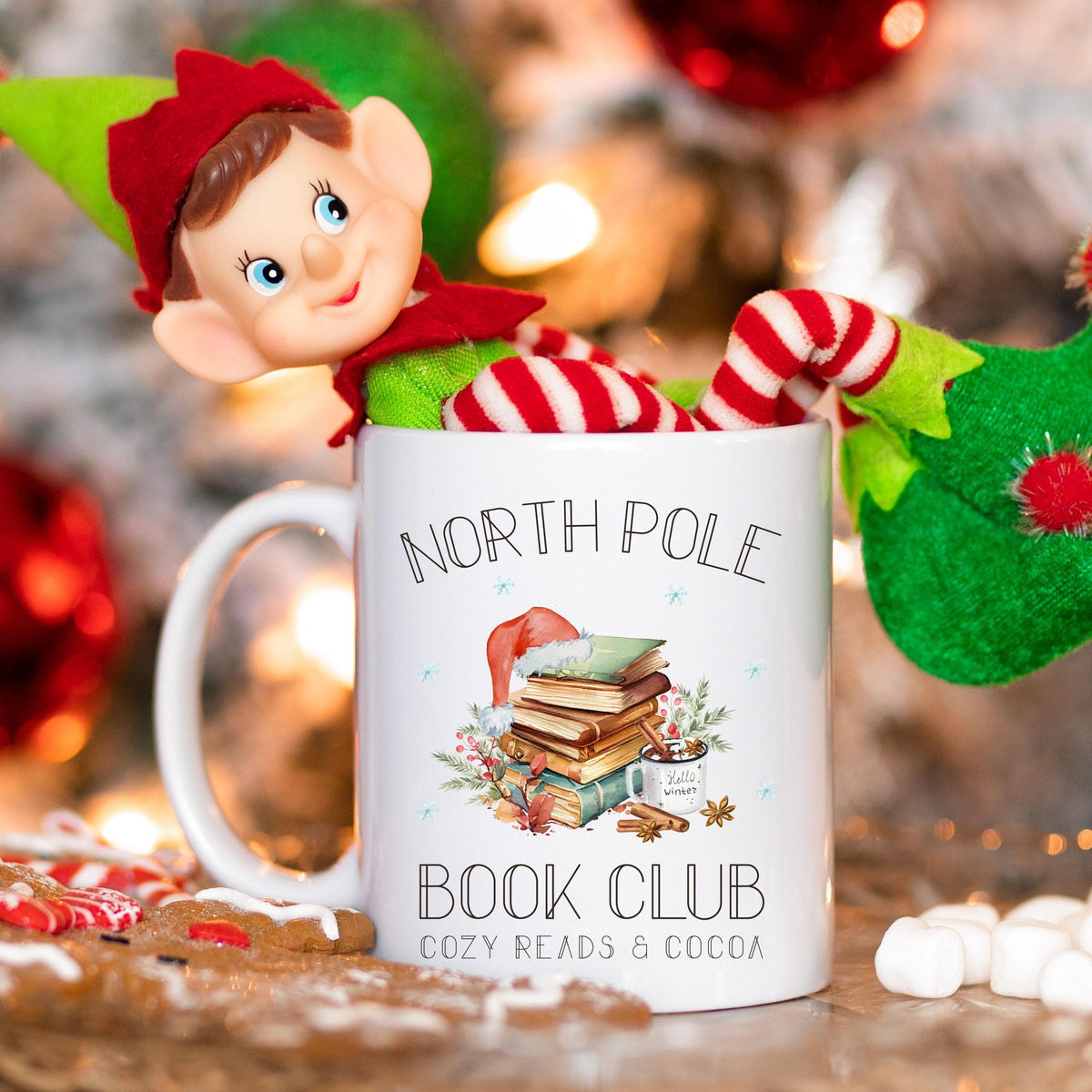 Weihnachtstasse „North Pole Book Club“ mit winterlichem Bücher-Motiv – perfektes Geschenk für Buchliebhaber, Leseratten und Weihnachtsfans. Die Tasse zeigt einen festlich dekorierten Bücherstapel mit Weihnachtsmütze, umgeben von winterlichen Elementen. Ideal als Geschenkidee zu Weihnachten für Vielleser, Buchclub-Mitglieder, Literaturfreunde, Kolleginnen oder Lehrerinnen. Ein liebevolles Präsent für Advent, Nikolaus oder Heiligabend – für gemütliche Lesemomente mit Kakao, Tee oder Kaffee