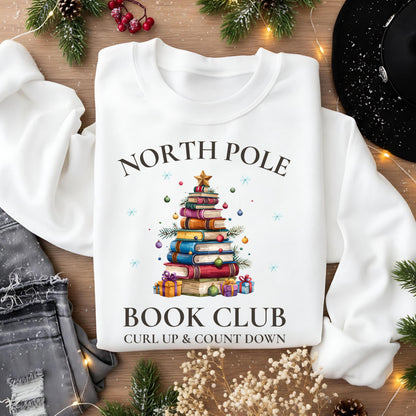 Weihnachtlicher Sweater für Damen mit Buchbaum-Motiv und „North Pole Book Club“-Schriftzug. Perfekter Winterpullover für Leseratten, Bücherliebhaberinnen und gemütliche Lesestunden. Ideal als Geschenk für Frauen, Lehrerinnen, Kolleginnen oder als Wichtelgeschenk zu Weihnachten. Das kuschelige Sweatshirt kombiniert Weihnachtszauber mit Buchliebe – ein festliches Outfit für Advent, Lesecouch und Buchclub-Treffen. Für alle, die ihre Liebe zu Geschichten auch modisch zeigen wollen.