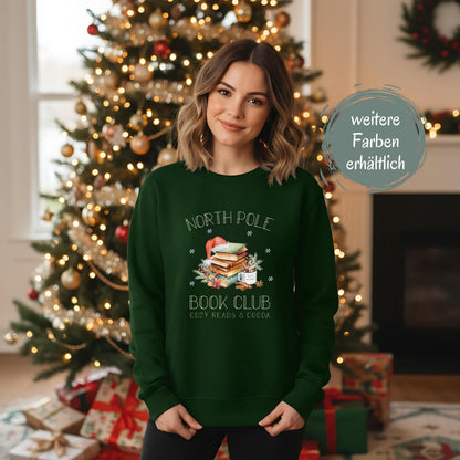 Weihnachtspullover für Damen mit Bücherstapel, Weihnachtsmütze und Kakao – perfektes Winter-Outfit für Leseratten und Buchliebhaberinnen. Der Sweater zeigt das Motiv „North Pole Book Club – Cozy Reads & Cocoa“ und verbindet Weihnachtsfreude mit Leseleidenschaft. Ideal als Geschenk zu Weihnachten oder Nikolaus für Frauen, die Bücher lieben. Ein kuscheliges, winterliches Oberteil für gemütliche Lesestunden, Weihnachtsfeiern oder den Advent. ein süßer Hingucker für die festliche Saison!