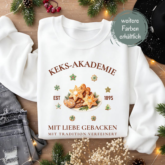 Lustiger Weihnachtspullover mit Plätzchenmotiv und der Aufschrift „Keks-Akademie – Mit Liebe gebacken, mit Tradition verfeinert“. Perfekt für Damen und Herren als Winterpullover für Weihnachten, Advent, Nikolaus oder Weihnachtsmarkt. Tolles Geschenk für Frauen, Männer, Kolleginnen oder als Wichtelgeschenk. Der Sweater vereint Weihnachtsfreude, Humor und Nostalgie – ideal für Plätzchenliebhaber, Familienfotos, Bäcker und winterliche Outfits voller Zimtduft und Herz.