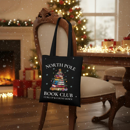Baumwoll-Stofftasche mit weihnachtlichem Motiv: Ein Bücherbaum mit Stern und Geschenken symbolisiert den „North Pole Book Club“. Perfekt als Jutebeutel Weihnachten für Leseratten, Bücherfreunde, Bibliophile oder Buchclub-Mitglieder. Ideales Geschenk für Buchliebhaber und als nachhaltige Geschenkverpackung mit Buchthema zur Adventszeit. Baumwolltasche für Weihnachten & Buchfans. WeihnachtsStofftasche für Bücherfreunde! Der Jutebeutel ist das perfekte Geschenk für Buchliebhaber zur Adventszeit.