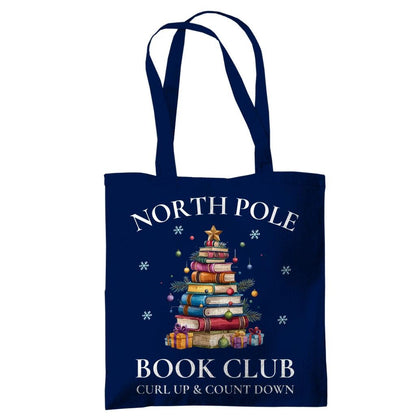 Baumwoll-Stofftasche mit weihnachtlichem Motiv: Ein Bücherbaum mit Stern und Geschenken symbolisiert den „North Pole Book Club“. Perfekt als Jutebeutel Weihnachten für Leseratten, Bücherfreunde, Bibliophile oder Buchclub-Mitglieder. Ideales Geschenk für Buchliebhaber und als nachhaltige Geschenkverpackung mit Buchthema zur Adventszeit. Baumwolltasche für Weihnachten & Buchfans. WeihnachtsStofftasche für Bücherfreunde! Der Jutebeutel ist das perfekte Geschenk für Buchliebhaber zur Adventszeit.