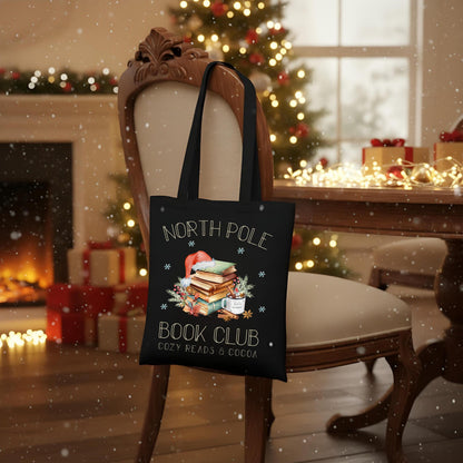 Baumwoll‑Jutebeutel mit weihnachtlichem Bücherbaum‑Motiv und Schriftzug „North Pole Book Club“. Ideal als Stofftasche Weihnachten für Leseratten, Buchliebhaber und Bibliophile – passend als Geschenk oder Einkaufstasche in der Advents‑ und Winterzeit. Hochwertige Baumwolltasche, langlebiger Druck, lange Henkel, umweltfreundlich und vielseitig nutzbar. Perfekt als Weihnachts‑Geschenktasche, Bücherbeutel oder nachhaltige Tasche mit Weihnachtsmotiv für Freunde, Familie oder für dich selbst.