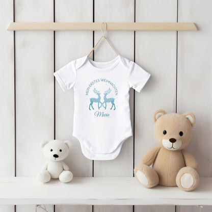 Personalisierter Babybody für Weihnachten 2025 mit zwei glitzernden Rentieren in Blau, Aufschrift „Mein erstes Weihnachten“ und individuellem Namen (z. B. Maja). Ideal als Geschenk für Babys erstes Weihnachtsfest oder für Dezemberbabys. Aus 100 % Bio-Baumwolle, wahlweise mit Kurzarm oder Langarm. Perfekt für festliche Familienfotos, Erinnerungsboxen oder Partnerlook mit Eltern & Geschwistern. Hochwertiger Direktdruck, hautfreundlich, waschbar bei 30 °C. Zauberhaftes Outfit für dein Winterbaby.