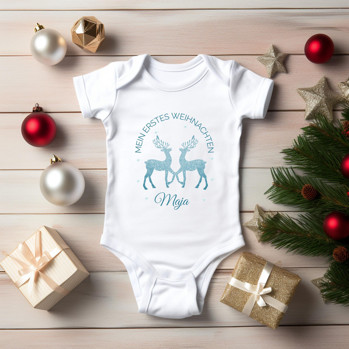 Personalisierter Babybody für Weihnachten 2025 mit zwei glitzernden Rentieren in Blau, Aufschrift „Mein erstes Weihnachten“ und individuellem Namen (z. B. Maja). Ideal als Geschenk für Babys erstes Weihnachtsfest oder für Dezemberbabys. Aus 100 % Bio-Baumwolle, wahlweise mit Kurzarm oder Langarm. Perfekt für festliche Familienfotos, Erinnerungsboxen oder Partnerlook mit Eltern & Geschwistern. Hochwertiger Direktdruck, hautfreundlich, waschbar bei 30 °C. Zauberhaftes Outfit für dein Winterbaby.