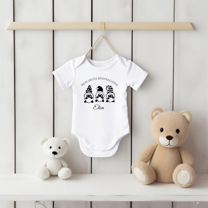 Weihnachtlicher Babybody mit Wichtel-Motiv „Ho Ho Ho“ und dem Schriftzug „Mein erstes Weihnachten“ – personalisiert mit Namen. Das festliche Design eignet sich als Weihnachtsoutfit für Babys, ideal für Jungen und Mädchen. Der Body besteht aus weicher Bio-Baumwolle und ist perfekt für Winterbabys 2025. In Weiß, wählbar mit Langarm oder Kurzarm. Perfekt als Geschenkidee für Eltern, für Fotos unterm Baum oder den ersten Familienbesuch bei Oma & Opa. Nachhaltig produziert und liebevoll bedruckt.