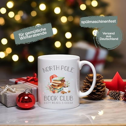 Weihnachtstasse „North Pole Book Club“ mit winterlichem Bücher-Motiv – perfektes Geschenk für Buchliebhaber, Leseratten und Weihnachtsfans. Die Tasse zeigt einen festlich dekorierten Bücherstapel mit Weihnachtsmütze, umgeben von winterlichen Elementen. Ideal als Geschenkidee zu Weihnachten für Vielleser, Buchclub-Mitglieder, Literaturfreunde, Kolleginnen oder Lehrerinnen. Ein liebevolles Präsent für Advent, Nikolaus oder Heiligabend – für gemütliche Lesemomente mit Kakao, Tee oder Kaffee