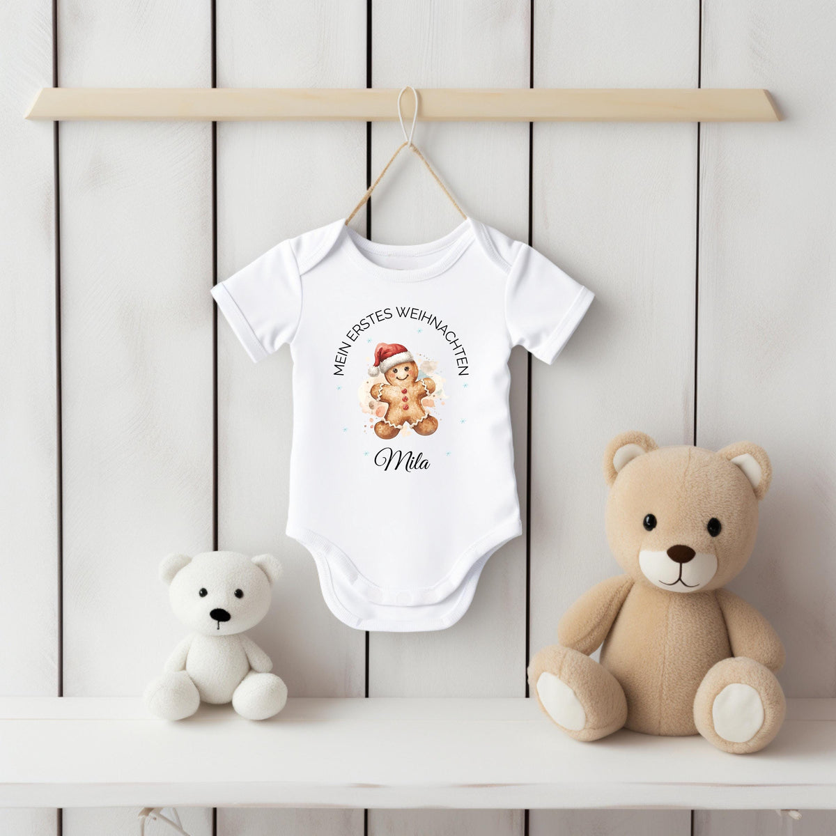 Mein erstes Weihnachten Babybody Weihnachten 2025 aus weißer Bio-Baumwolle mit Lebkuchenmann-Motiv und Text „Mein erstes Weihnachten“. Name des Babys wird personalisiert unter das Motiv gedruckt. Ideal als Weihnachtsoutfit Baby, Babybody personalisiert, Geschenk zur Geburt oder Taufe im Winter. Kurzarm oder Langarm wählbar. Weicher Stoff, hautfreundlich, maschinenwaschbar, nachhaltiger Direktdruck. Perfekt für Neugeborene, Familienfotos, Partnerlook, Baby-Erinnerung oder Babyparty-Geschenk.