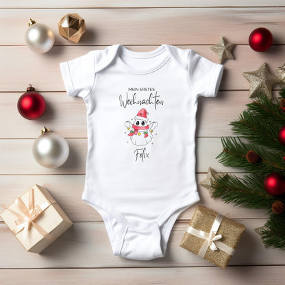 Babybody Weihnachten 2025 aus weißer Bio-Baumwolle mit rosa Weihnachtsgeist-Motiv, Nikolausmütze, buntem Schal und Sternen. Text „Mein erstes Weihnachten“ über dem Motiv, Name des Babys darunter personalisiert (z. B. Matteo). In Langarm oder Kurzarm wählbar. Ideal als Babybody personalisiert, Weihnachtsoutfit Baby, Geschenk zur Geburt oder Taufe im Winter. Hautfreundlich langlebiger Druck. Perfekt für Familienfotos, Partnerlook mit Geschwistern oder als festliche Babykleidung zur Weihnachtszeit.