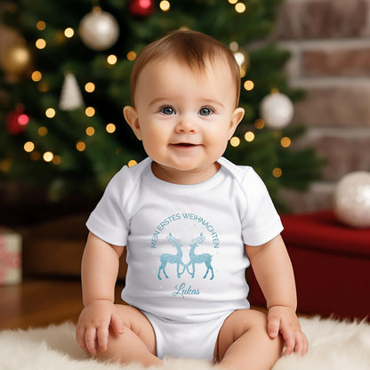 Personalisierter Babybody für Weihnachten 2025 mit zwei glitzernden Rentieren in Blau, Aufschrift „Mein erstes Weihnachten“ und individuellem Namen (z. B. Maja). Ideal als Geschenk für Babys erstes Weihnachtsfest oder für Dezemberbabys. Aus 100 % Bio-Baumwolle, wahlweise mit Kurzarm oder Langarm. Perfekt für festliche Familienfotos, Erinnerungsboxen oder Partnerlook mit Eltern & Geschwistern. Hochwertiger Direktdruck, hautfreundlich, waschbar bei 30 °C. Zauberhaftes Outfit für dein Winterbaby.