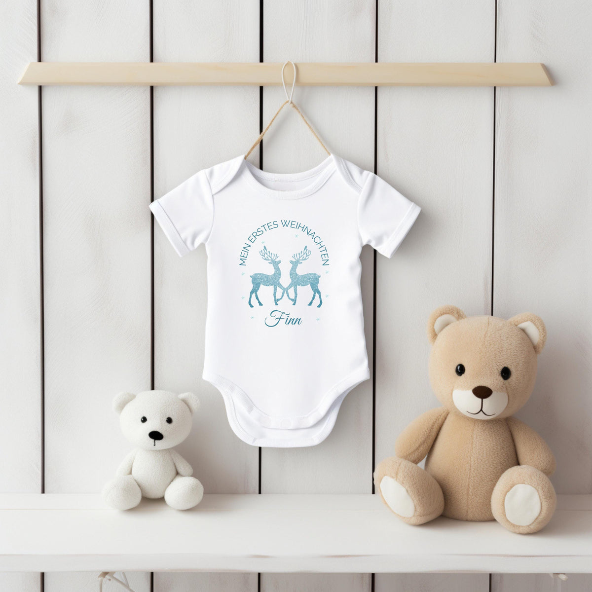 Personalisierter Babybody für Weihnachten 2025 mit zwei glitzernden Rentieren in Blau, Aufschrift „Mein erstes Weihnachten“ und individuellem Namen (z. B. Maja). Ideal als Geschenk für Babys erstes Weihnachtsfest oder für Dezemberbabys. Aus 100 % Bio-Baumwolle, wahlweise mit Kurzarm oder Langarm. Perfekt für festliche Familienfotos, Erinnerungsboxen oder Partnerlook mit Eltern & Geschwistern. Hochwertiger Direktdruck, hautfreundlich, waschbar bei 30 °C. Zauberhaftes Outfit für dein Winterbaby.
