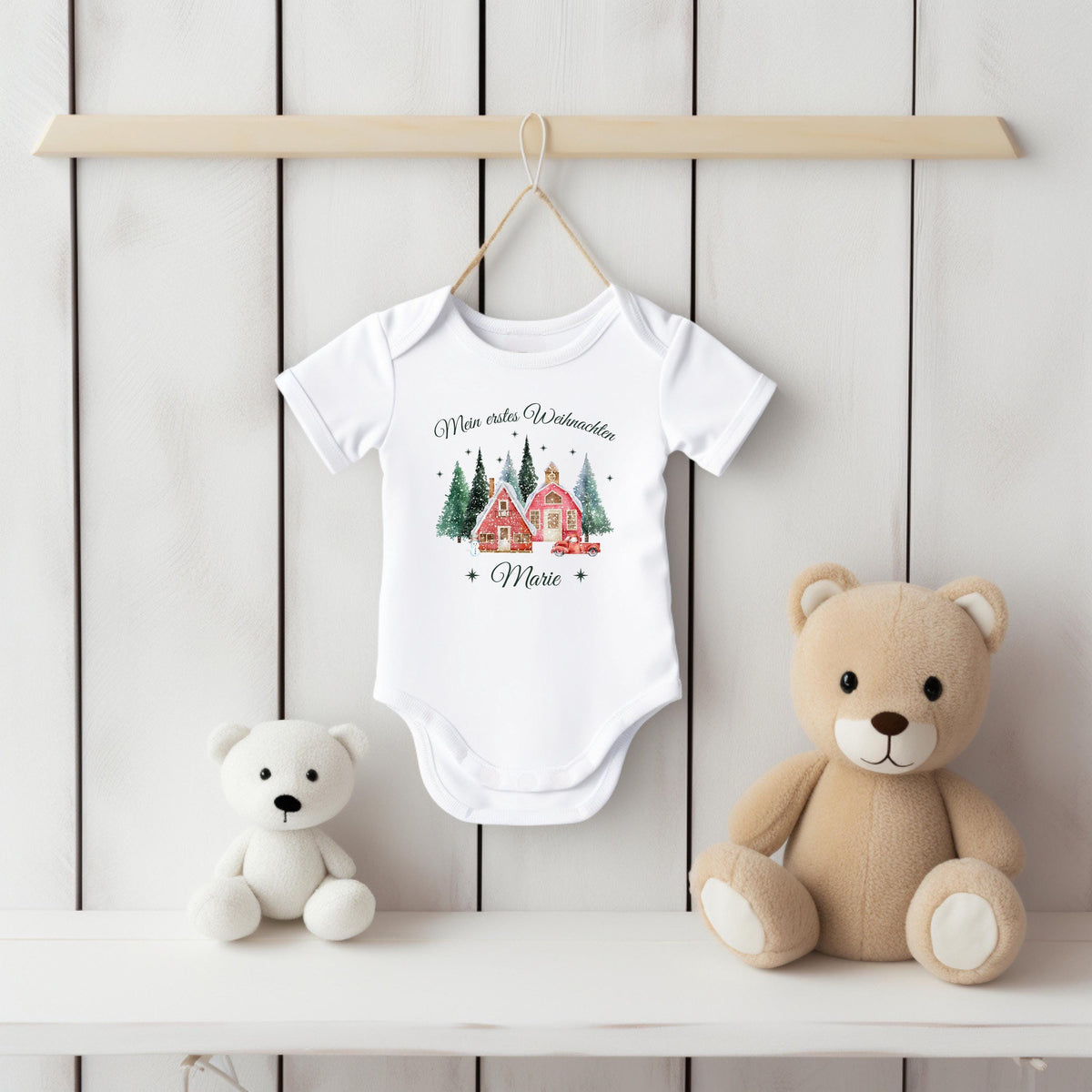 Babybody „Mein erstes Weihnachten“ mit nostalgischem Weihnachtsdorf-Motiv: zwei rote Häuser, verschneite Tannen und ein Vintage-Auto mit Weihnachtsbaum. Inklusive personalisiertem Namen (z. B. Luisa) unter dem Design. Aus 100 % Bio-Baumwolle, in Kurzarm oder Langarm erhältlich. Ideal als Geschenk zur Wintergeburt oder fürs erste Weihnachtsfest. Perfekt für Erinnerungsfotos, Familienfeiern oder Partnerlook mit Mama und Papa. Zauberhaftes Baby-Outfit für Weihnachten 2025.