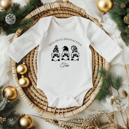 Weihnachtlicher Babybody mit Wichtel-Motiv „Ho Ho Ho“ und dem Schriftzug „Mein erstes Weihnachten“ – personalisiert mit Namen. Das festliche Design eignet sich als Weihnachtsoutfit für Babys, ideal für Jungen und Mädchen. Der Body besteht aus weicher Bio-Baumwolle und ist perfekt für Winterbabys 2025. In Weiß, wählbar mit Langarm oder Kurzarm. Perfekt als Geschenkidee für Eltern, für Fotos unterm Baum oder den ersten Familienbesuch bei Oma & Opa. Nachhaltig produziert und liebevoll bedruckt.
