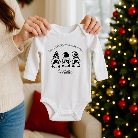 Weihnachtlicher Babybody mit Wichtel-Motiv „Ho Ho Ho“ und dem Schriftzug „Mein erstes Weihnachten“ – personalisiert mit Namen. Das festliche Design eignet sich als Weihnachtsoutfit für Babys, ideal für Jungen und Mädchen. Der Body besteht aus weicher Bio-Baumwolle und ist perfekt für Winterbabys 2025. In Weiß, wählbar mit Langarm oder Kurzarm. Perfekt als Geschenkidee für Eltern, für Fotos unterm Baum oder den ersten Familienbesuch bei Oma & Opa. Nachhaltig produziert und liebevoll bedruckt.